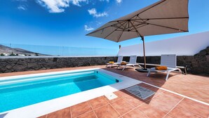 A swimming pool with a stone wall and a clear view of the ocean. - Lanzarote Paradise - Pool, AACC and BBQ By LVH (Playa Blanca)