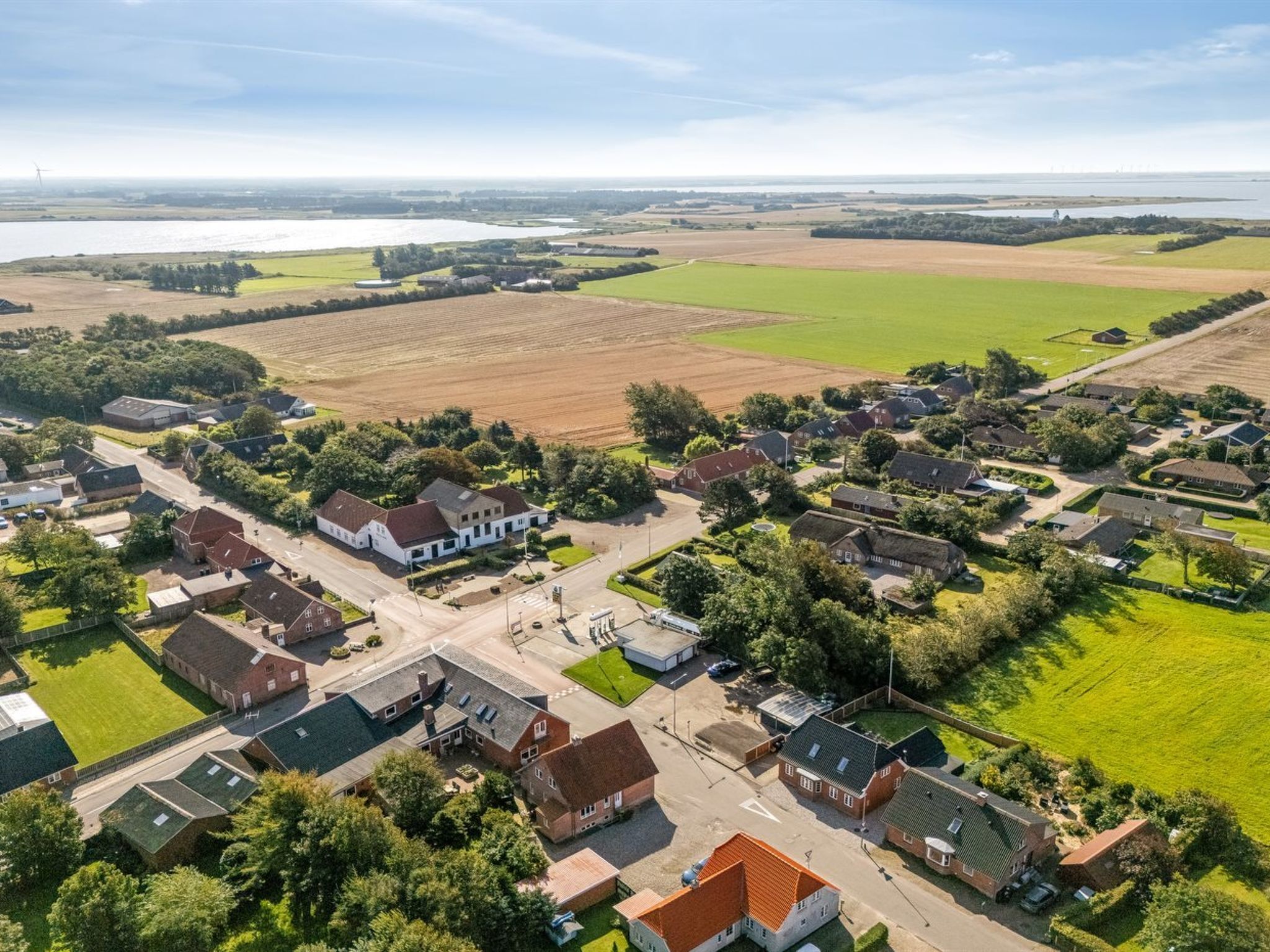 An aerial view of a residential area with houses, roads, and fields.