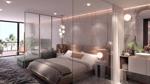 A modern bedroom with a large bed, bedside tables, a vanity with a mirror, and a balcony view. - Gajrash Suites (Baku)