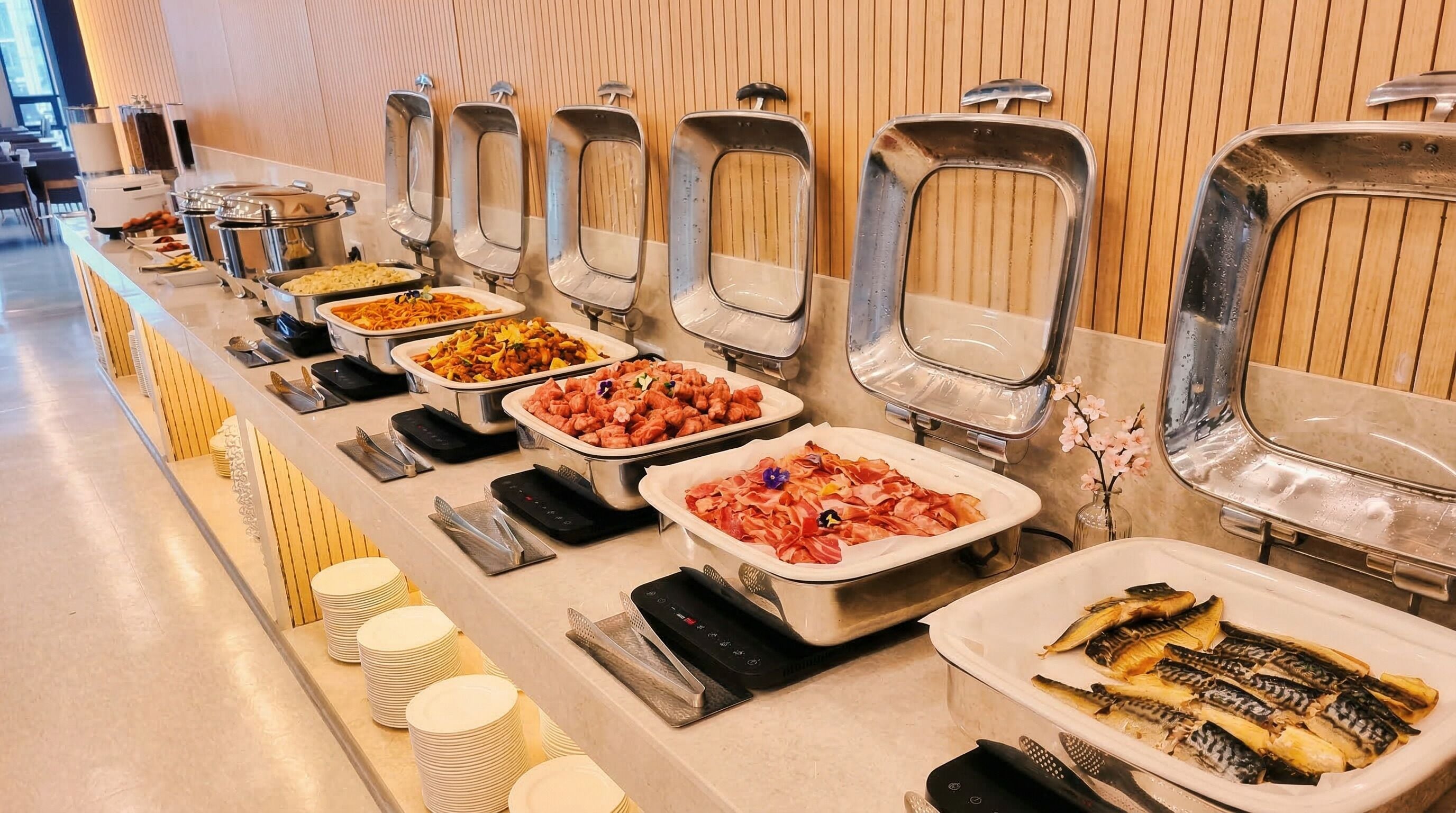 Un buffet proposant une variété de plats, notamment des pâtes, de la viande et du poisson.