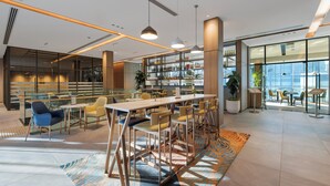 A modern interior with a bar area, seating, and a view through large windows.