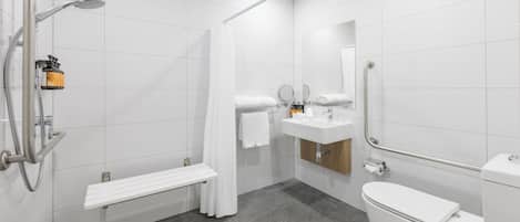 Un baño moderno con ducha, inodoro, lavabo y banco.