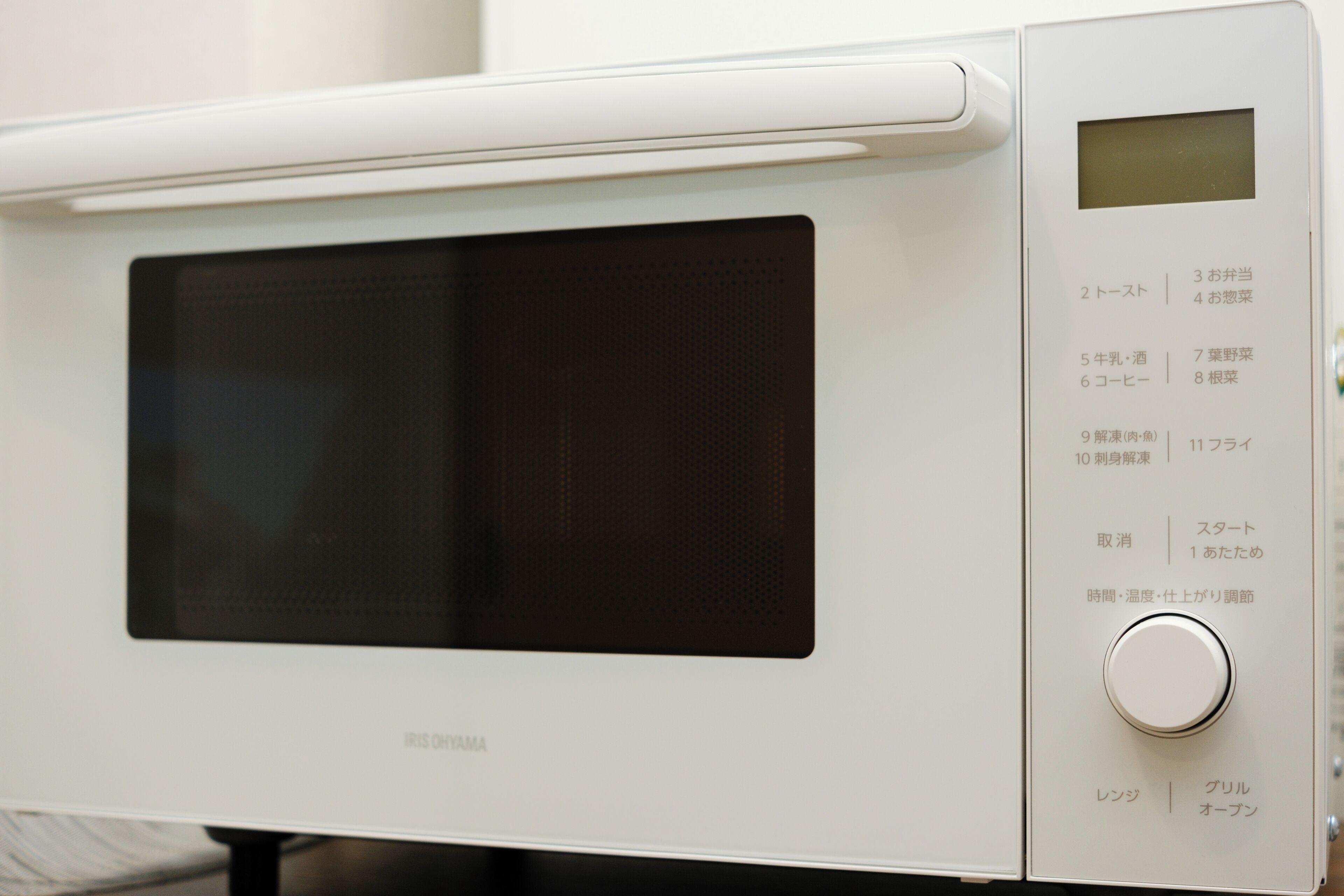 A white microwave with Japanese labels and a digital display.