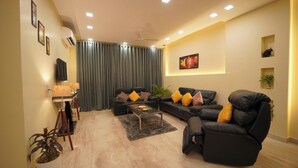 Una sala moderna con un conjunto de sofás, una mesa de centro y un televisor.
