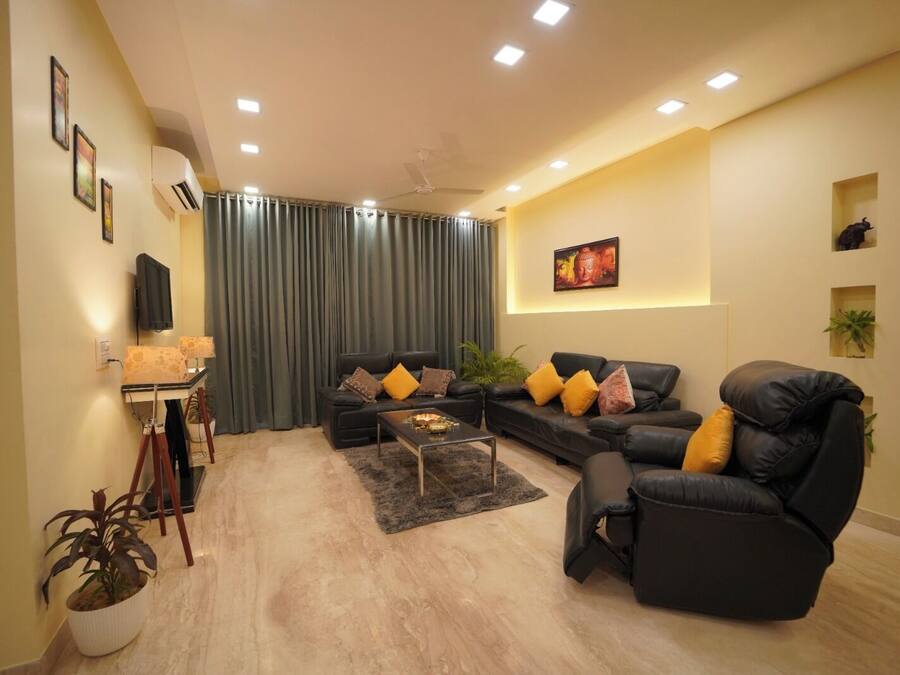 Una sala moderna con un conjunto de sofás, una mesa de centro y un televisor.