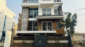 Un edificio residencial moderno de varios pisos con techo plano, ventanas amplias y fachada decorativa.