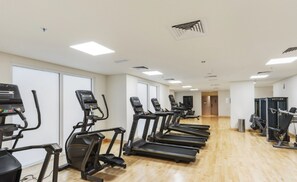 A fitness center with treadmills and elliptical machines arranged in rows. - Charming Retreat w Panoramic Views on Yas Island (Abu Dhabi)