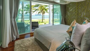 A bedroom with a large bed, a view of palm trees and the sea, and a balcony with a chair. - Coastal Escape Koh Yao Noi (Ko Yao)