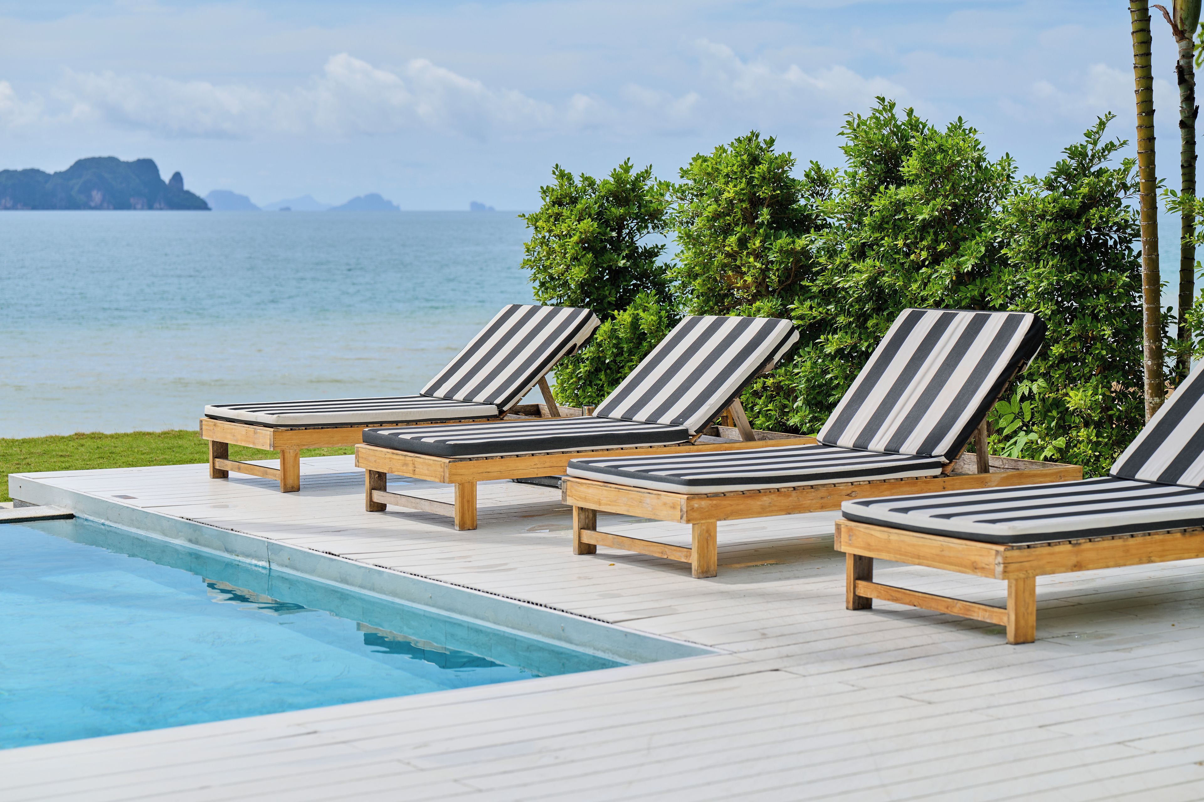 A poolside area with lounge chairs and a pool.
