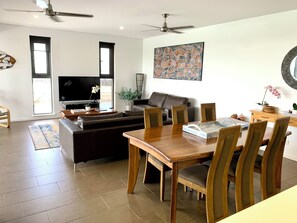 Relax in the spacious living room with a comfortable sofa, flat-screen TV, and dining area.