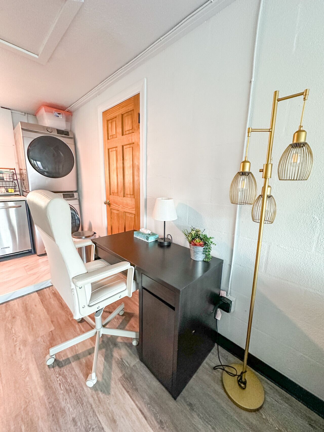 A compact office space with a desk, chair, lamp, and floor lamp.
