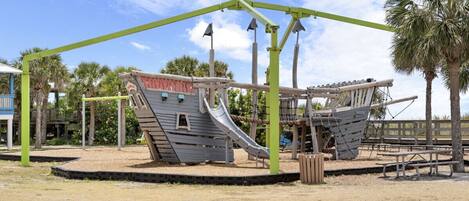 A playground with a pirate ship theme, including slides and climbing structures.