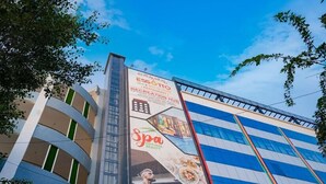 A building with a large billboard advertising ESSOTTO, a recreation hub, and a spa. - Essotto Recreation Hub (Bengaluru)