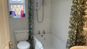 A bathroom with a toilet, bathtub, and shower. - Snaith Central Apartment (Goole)
