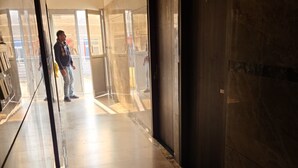 A hallway with a marble floor, a large mirror, and a door leading to another room.