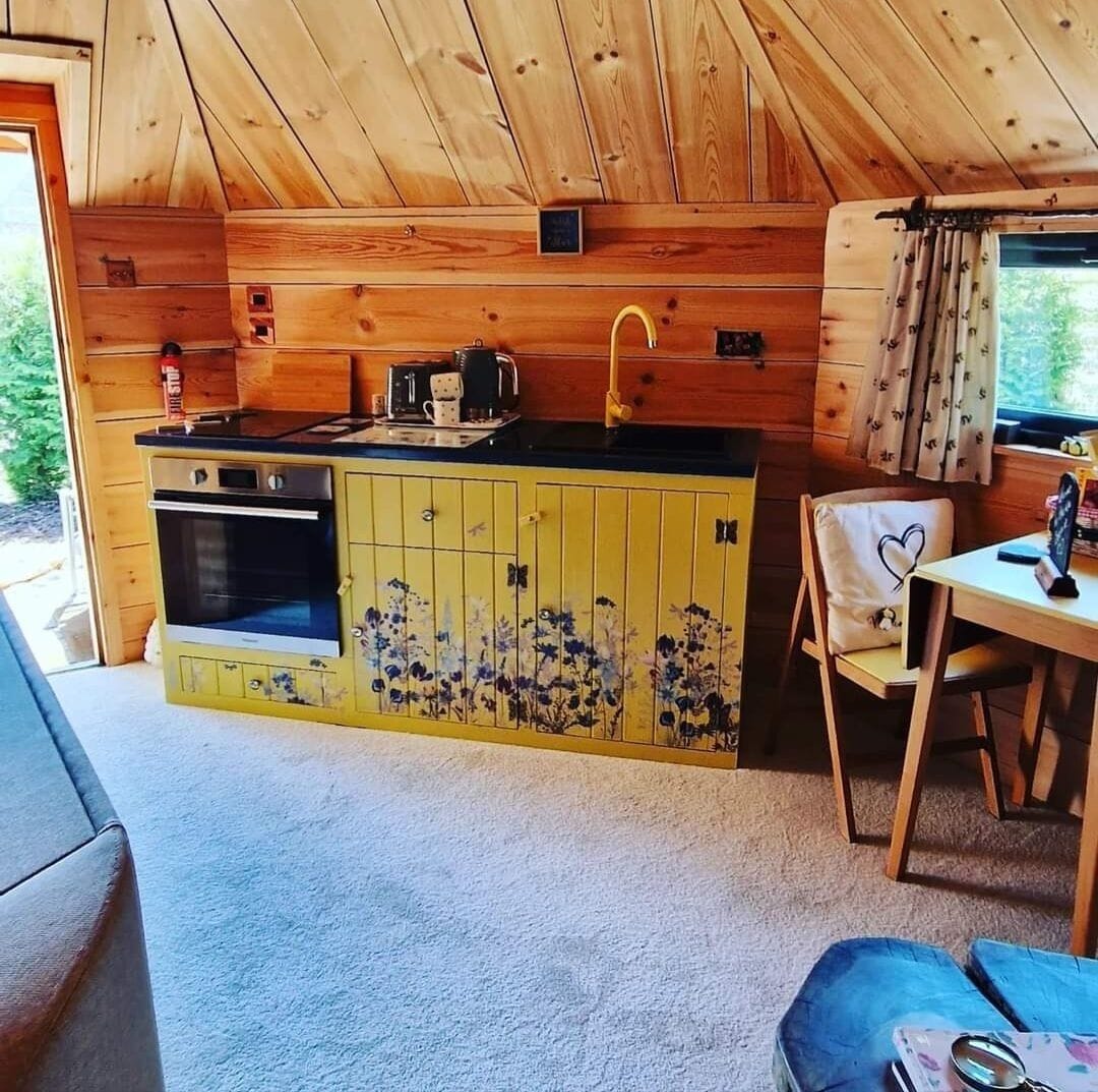 Una cocina compacta con armarios de madera, un lavamanos y una estufa.
