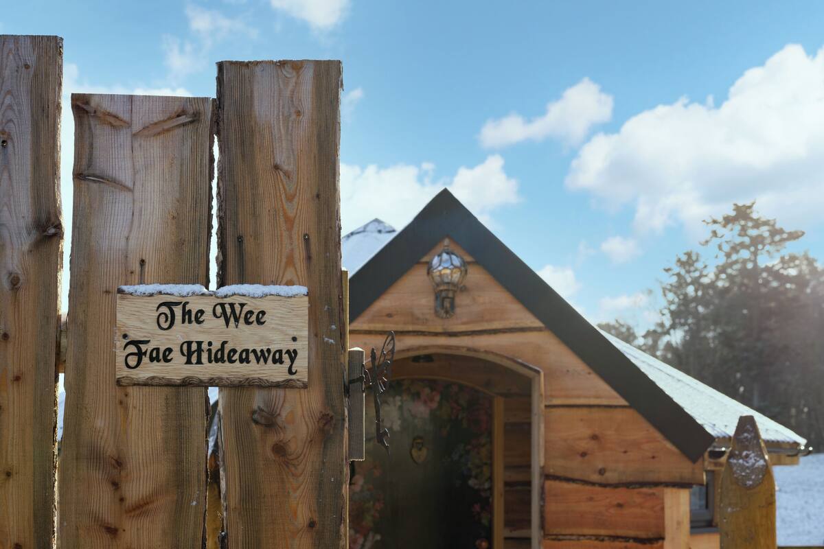 A wooden gate with a sign reading "The Wee Fae Hideaway."