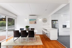 Una cocina moderna con armarios blancos, un refrigerador de acero inoxidable y un microondas.