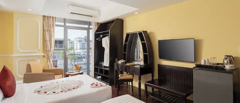 A hotel room with two beds, a TV, a desk, a wardrobe, and a view of the city.