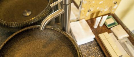 A bathroom sink with a modern faucet and a soap dispenser.