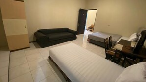 A bedroom with a bed, a sofa, a desk, and a chair. - Hotel O Sweet Home Residence Simpang Lima (Semarang)