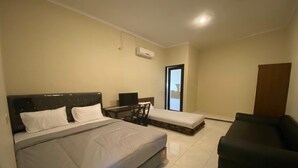 A bedroom with a large bed, a desk, a chair, and a sofa. - Hotel O Sweet Home Residence Simpang Lima (Semarang)