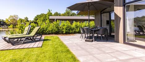 Une terrasse extérieure moderne dotée d’une piscine, d’un coin repas et de chaises longues.