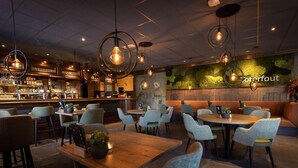 Un restaurante con zona de bar, disposición de mesas y una pared verde con el nombre 'Jeterfout'.