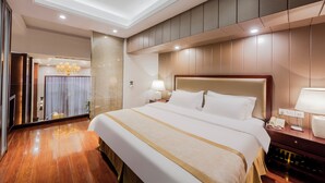 Una habitación de hotel con una cama grande, una mesita de noche con lámpara y un espejo.
