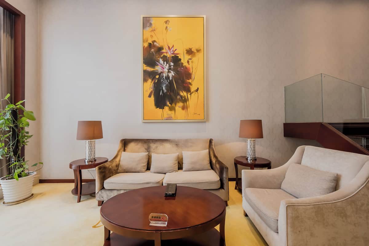 Un salon moderne avec un ensemble de canapés, une table basse et un tableau accroché au mur.