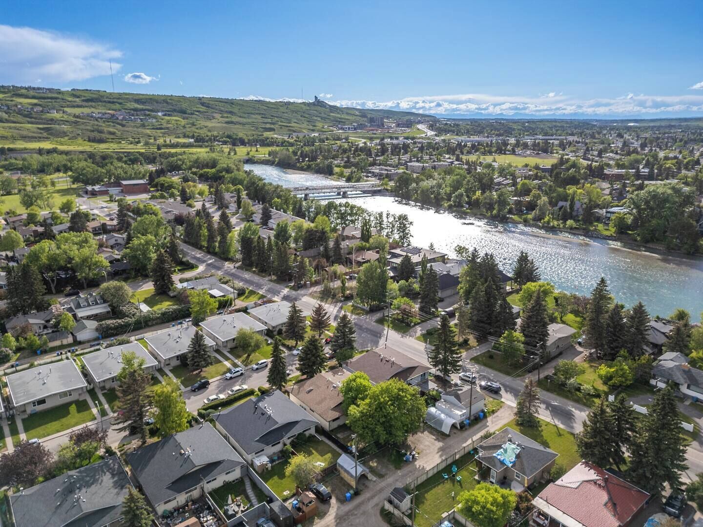 Luchtbeeld van een woongebied met huizen, een rivier en een brug.