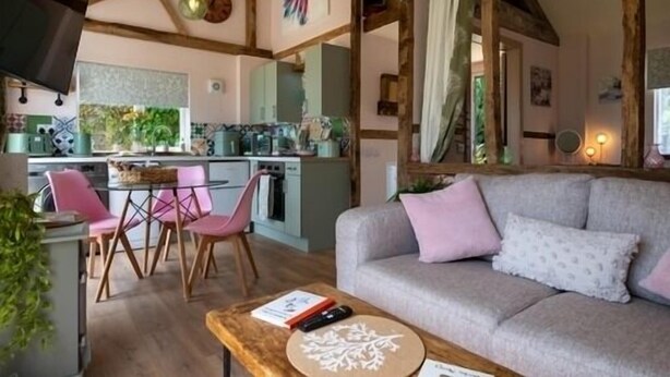 Uma sala de estar acolhedora com sofá, mesa de centro e um espaço de jantar com cadeiras e mesa.