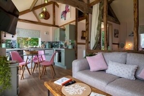 Un salon confortable avec un canapé, une table basse et un coin repas comprenant des chaises et une table.