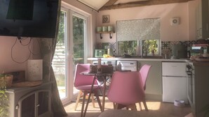 Uma cozinha aconchegante com área de jantar, televisão e um relógio na parede.
