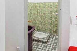 A bathroom with a toilet, a sink, and a shower area. - Hotel O Rafie Exclusive 2 Syariah (Jambi)