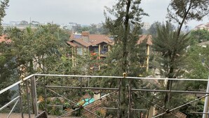 A balcony with a view of residential buildings and trees. - Woodmere Grand Hotel (Nairobi)