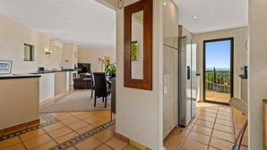 A modern apartment with a kitchen, dining area, and a balcony with a view. - Luxury 4 bed Villa with private pool Bendinat (Palma de Mallorca)
