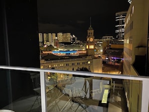 A nighttime cityscape with a prominent clock tower and illuminated buildings.