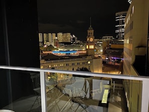 A nighttime cityscape with a prominent clock tower and illuminated buildings.