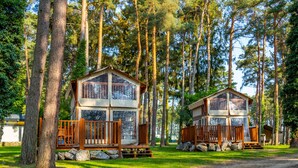 Two wooden cabins in a forest with a dirt path in front. - Tent Lodge With Bathroom 16 km From Maastricht (Zutendaal)