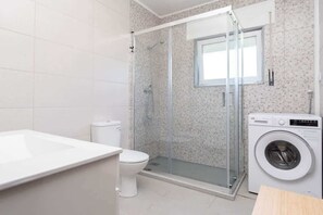 Chuveiro, secador de cabelo, toalhas de banho, shampoo