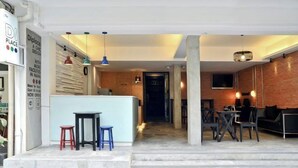 A modern interior with a bar area, seating, and a staircase leading to another level.