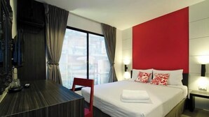 A hotel room with a bed, a desk, and a chair.