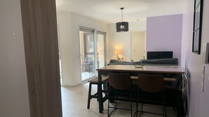 Cozinha moderna com mesa de jantar, cadeiras e luminária pendente.