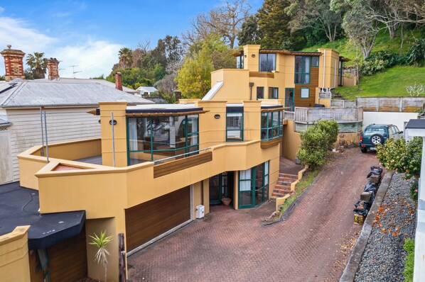 A modern two-story house with a garage, a driveway, and a car parked in the driveway.