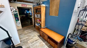 A room with a wooden cabinet, a desk, and a blue wall. There is a sign that says "ON AIR" and a door leading to another room.