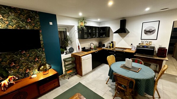 A compact kitchen with a dining area, a microwave, a sink, and cabinets.