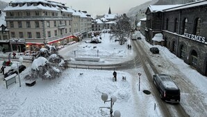 A snow-covered street with buildings, including a hotel with a sign that reads "HOTEL".