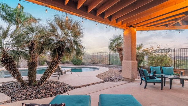 A covered outdoor area with a pool, lounge chairs, and palm trees. - Serene desert escape w/ stunning mountain views & heated pool/spa- pet friendly! (Tucson)