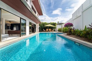 A swimming pool with a patio area, a dining table, and chairs. - Tropical 3BR Pool Villa Amaya in Kamala (Kamala)